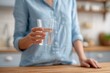 © ryker - Close up of woman hand holding clear glass of water, showcasing refreshing drink in cozy kitchen setting. soft lighting enhances inviting atmosphere