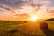 © Eugene_Photo - Scenic sunset over hay bales in a field. Golden light bathes the landscape, creating a tranquil scene. For agriculture, travel and inspiring greeting card designs.