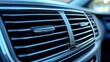© Nice Seven - Close-up image of a car air conditioning vent with adjustable slats inside a modern vehicle interior.