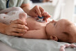 © New Africa - Pediatrician examining baby with stethoscope at table in clinic, closeup