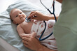 © New Africa - Pediatrician examining baby with stethoscope at table in clinic, closeup