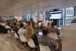 © Oleh - Business people are attending a presentation in a conference room, watching a large screen displaying data and charts, during a business meeting in a modern office