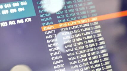 Computer code displayed on a screen shows programming data