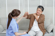 © Ekkasit A Siam - Asian female physiotherapist gently holding arm of senior asian woman pointing to painful shoulder during physical therapy consultation in private rehabilitation room with white blinds