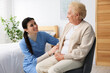 © New Africa - Nurse assisting senior woman indoors. Home health care service