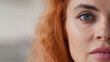 © Yuliia - Portrait half face cropped view Caucasian redhead woman looking at camera calm serious look health medicine feminism skincare girl female eyesight human perfect skin close up indoors domestic violence