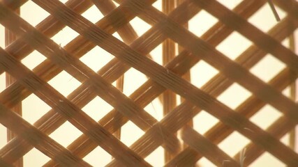 Close-up of woven natural fiber pattern with light shining through