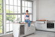 © Pixel-Shot - Young woman with furniture assembly plan sitting on counter in kitchen