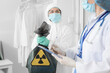 © Pixel-Shot - Workers in protective uniforms and with bag of radioactive waste in clinic