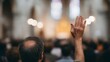 © fotogurme - Seated amidst candle-lit solemnity, a hand raised in reverence, echoing All Saints' Day spiritual communion, diverse community ritual