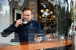 © Westend61 - Businessman with smart phone drinking coffee in cafe