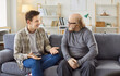 © Studio Romantic - Adult son and a senior father talking. Old man in his 60s sitting on the couch together with his grown up son and listening to him ready to share his life wisdom. Parents and children concept
