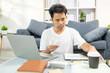 © Kield KD - A man spends his vacation paying bills with his laptop, coffee cups and credit cards, and he is looking for a moment to relax after all this activity.A man spends his vacation paying bills with his