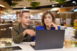 © Ranta Images - Gender diverse coworker business team eating salad and working digitally