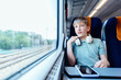 © Iryna - Teen boy with headphones relaxing by train window