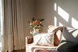 © Wavebreak Media - Coral-colored sofa sitting near window, adorned with pillows, throw, and variegated plant