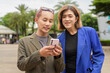 © Ranta Images - Gender diverse business coworker professionals using technology on city street