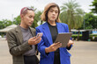 © Ranta Images - Gender diverse business coworker professionals using technology on city street