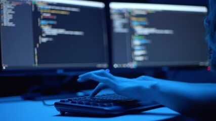 Coding in Dark: Focused programmer diligently codes in a dimly lit room, the glow of multiple monitors illuminating the complex lines of code on the screen.
