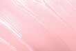 © New Africa - Sample of clear lip gloss on pink background, top view