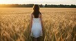 © Gunung - Woman walking through golden wheat field sunset