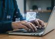 © trendee - Person typing on laptop with glowing email icons