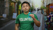 © Krakenimages.com - Young man wearing volunteer shirt holding blue ribbon on city street raising cancer awareness in urban setting.