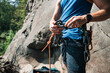 © Cavan Images - man clipping quick draws to carabiner's whilst outdoor climbing