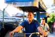 © Mdv Edwards - Two Filipino tricycle drivers share a joyful moment during a bright morning commute, smiling warmly at the camera while waiting on the street in Metro Manila.