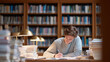 © Lumi Stock Studio - young student studying in library, student in library