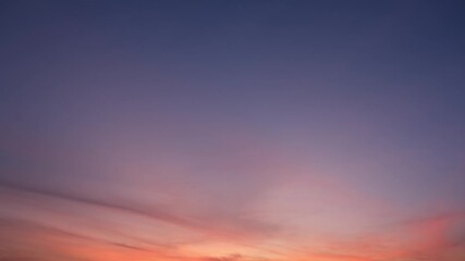 Wall Mural - A calm sunrise sky timelapse with soft orange and pink streaks spreading gently across a purple and blue sky, creating a peaceful and hopeful start to the day with warm, glowing hues. Time-lapse.
