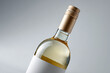 © EricMiguel - Close-up of a sleek bottle of white wine with gold screw cap and blank label on a light gray background