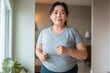 © Prazis Images - Overweight Asian Woman Exercising Indoors Confidently