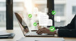 © Nimra - Preparation of documents. Documents and checkmark. Compliance and documentation. Hands typing on laptop computer keyboard. Businessman working at desk in office