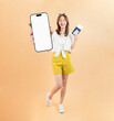 © sitthiphong - Happy smiling young Asian woman holding smartphone mockup of blank screen and passport with plane tickets and credit card on beige color background. Tourist travel trip journey concept.