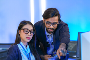 asian female ai programmer and indian male data analyst reviewing code on a monitor. diverse tech pr