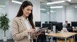 © ADesign - Smiling businesswoman using tablet in modern office, open-plan workspace