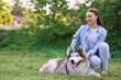 © New Africa - Happy woman with her cute Alaskan malamute dog on green grass outdoors. Space for text
