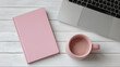 © Nuttawut - Workspace Essentials: A minimalist workspace showcases a pink notebook, a sleek laptop, and a matching mug on a clean, light-colored desk, ideal for productivity and creative endeavors.