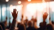© Shelley - Business professionals raising hands during a conference presentation in a modern meeting room, emphasizing participation and engagement.
