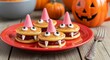 © Subrata - Adorable halloween witch hat pancakes with spooky candy eyes and fangs on a red plate