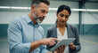© Bakha - Focused business colleagues analyzing project together on digital tablet in modern industrial workspace confident teamwork and strategic discussion for successful collaboration and decision making