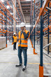 © Koldo_Studio - Warehouse manager talking on smartphone, coordinating logistics and managing inventory inside a large distribution center