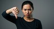 © Mono - Disapproving woman gives thumbs down gesture