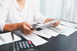 © doidam10 - Using calculating machine, household carefully manages each bill and expense to plan financial budget, ensuring timely payment, consistent saving, smart investment for secure home finance strategy.
