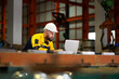 © NVB Stocker - Laptop computer : blue collar working production line : Caucasian man engineer worker working control sheet metal roof tile roll forming machine at metal sheet profiling factory. Industrial production