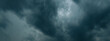 © Emvats - Thick, dark storm clouds swirl and stretch across the sky in a dramatic display, creating a moody and atmospheric scene with copy space.