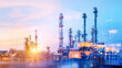 © Chineewan Somsap - Modern industrial complex with tall smokestacks and pipelines, illuminated by vibrant sunset, showcasing energy production and technology