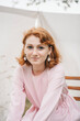 © Bohdan - Smiling young woman in pink dress with pearl earrings