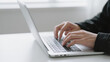 © Purwadani - Typing on a laptop keyboard, hands of a person working on a computer, close-up view